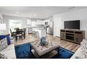 Open-concept living room and kitchen with hardwood floors, white cabinets, and stainless steel appliances at 238 Elyse Overlook Loop, Sanford, NC 27332