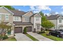Inviting townhouse with a two-car garage, manicured lawn, and stylish neutral-toned exterior at 265 Mariah Towns Way, Garner, NC 27529