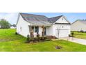 Attractive single-Gathering home with a manicured lawn and charming front porch featuring chairs at 295 Springtooth Dr, Zebulon, NC 27597