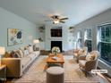 Bright, virtually staged living room featuring a fireplace, built-in shelves, and large windows at 312 Sarazen Dr, Clayton, NC 27527