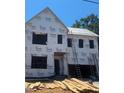 Two-story home during construction with wood stacked in the front yard and ladders leaning on the side at 406 Columbia Dr, Raleigh, NC 27604