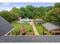 Expansive backyard aerial view featuring a pool, outdoor kitchen, fireplace, and lush landscaping, perfect for entertaining at 4769 Swordfish Dr, Raleigh, NC 27603