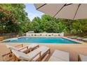 Relaxing poolside view with comfortable loungers and a clear blue pool surrounded by lush greenery and privacy wall at 4769 Swordfish Dr, Raleigh, NC 27603