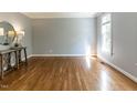 Sunlit living room with gleaming hardwood floors, neutral paint, and elegant trim at 4912 Sunset Forest Cir, Holly Springs, NC 27540