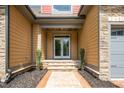 Inviting entrance with a covered porch, stone steps, wood accents, and manicured landscaping at 518 Ranch Farm Rd, Raleigh, NC 27603
