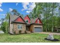 Charming exterior view showcasing the home's stone and siding details, plus an attached garage at 518 Ranch Farm Rd, Raleigh, NC 27603