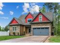 Beautiful home with a stone and siding exterior, featuring a gray garage door and manicured landscaping at 518 Ranch Farm Rd, Raleigh, NC 27603