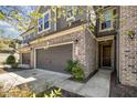 Stylish brick and siding townhome featuring a two-car garage and covered entry at 521 Rockcastle Dr, Cary, NC 27519