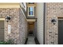 Welcoming front entrance with brick and siding, featuring a classic wooden door and stylish outdoor lighting at 521 Rockcastle Dr, Cary, NC 27519
