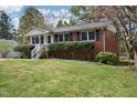Well-maintained brick home with mature landscaping, offering classic charm and curb appeal at 5218 Revere Rd, Durham, NC 27713