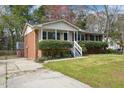 View of a charming brick home featuring a manicured lawn and a convenient driveway at 5218 Revere Rd, Durham, NC 27713
