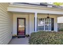 Inviting front porch with decorative door, manicured bushes, and a large window letting in natural light at 613 Holly Thorn, Holly Springs, NC 27540