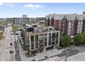 Modern apartment building with brick and grey facade, balconies, and rooftop terrace, in a developed area at 615 W Peace St # 201, Raleigh, NC 27605