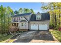 Charming two-story home with a two car garage, landscaped yard, and front porch at 7221 Messenger Dr, Willow Springs, NC 27592