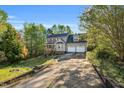 Beautiful home with a long drive, two-car garage and front porch nestled in a wooded lot at 7221 Messenger Dr, Willow Springs, NC 27592