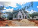 Two-story new home with gray siding, brick base, arch entryway and two car garage at 7436 Summer Tanager Trl, Raleigh, NC 27614