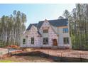 View of home in construction phase against the backdrop of tall trees at 7436 Summer Tanager Trl, Raleigh, NC 27614