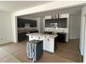 Open-concept kitchen with stainless steel appliances, dark cabinetry, and a large center island with a white countertop at 752 Swim Cave Ln, Wendell, NC 27591