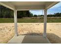 Covered patio with views of the undeveloped backyard and surrounding wooded area at 752 Swim Cave Ln, Wendell, NC 27591