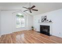 Bright living room with vaulted ceiling, a fireplace, and a large window allowing natural light at 8000 Elderson Ln, Raleigh, NC 27612