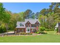 Beautiful two-story brick home surrounded by lush greenery, offering privacy and curb appeal at 8059 Hogan Dr, Wake Forest, NC 27587