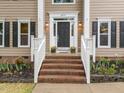 Inviting front entrance featuring brick steps, flower beds, and sidelights on front door at 8921 Walking Stick Trl, Raleigh, NC 27615