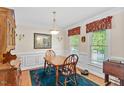 Traditional dining room featuring hardwood floors, elegant wainscoting, and a classic chandelier at 9204 Cub Trl, Raleigh, NC 27615