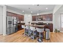 A kitchen boasts a central island with barstool seating and sleek, modern appliances on wood-look floors at 95 Shady Creek Trl, Garner, NC 27529