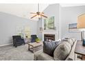 Bright living room with high ceilings, ceiling fan, cozy fireplace, and comfortable seating area at 12325 Inglehurst Dr, Raleigh, NC 27613