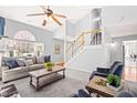 Spacious living room with a soaring ceiling, fireplace, staircase, and ample seating at 12325 Inglehurst Dr, Raleigh, NC 27613