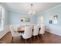 Dining room boasts a chandelier, light blue walls, hardwood floors, and a large wood table with upholstered chairs at 125 Kelekent Ln, Cary, NC 27518
