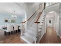 Elegant staircase with carpeted steps and wooden railings, complemented by hardwood floors and arched entryways at 125 Kelekent Ln, Cary, NC 27518