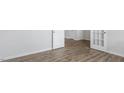Bedroom featuring wood-look floors, base trim, white walls, and a pair of white doors at 129 Pisgah St, Sanford, NC 27330