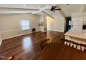 Spacious living room with gleaming hardwood floors, ceiling fan, and neutral wall color at 1308 Oakridge Ave # 3, Henderson, NC 27536