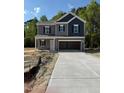 Charming two-story home featuring a gray and navy blue color scheme with a spacious two car garage at 136 Baneberry Pl, Broadway, NC 27505