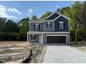 Charming two-story home featuring a gray and navy blue color scheme with a spacious two car garage at 136 Baneberry Pl, Broadway, NC 27505
