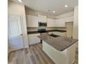 Bright kitchen features white cabinets, stainless steel appliances, and a granite-topped island at 136 Baneberry Pl, Broadway, NC 27505