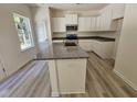 Well-lit kitchen boasts a granite-topped island, ample cabinet space, and stainless steel appliances at 136 Baneberry Pl, Broadway, NC 27505