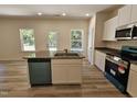 Open kitchen showcases a central island, white cabinets, and stainless steel appliances at 136 Baneberry Pl, Broadway, NC 27505