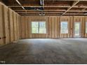 A framed living room featuring natural light, exposed beams, and unfinished flooring at 136 Baneberry Pl, Broadway, NC 27505