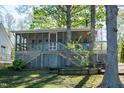 Backyard of lakehouse with large screened porch and stairs to treed yard at 150 Big Horn Cv, Louisburg, NC 27549