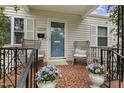 Inviting front porch with wicker chairs, tiled flooring, and decorative potted plants, offering a cozy outdoor space at 2008 Reaves Dr, Raleigh, NC 27608