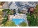 Aerial view of backyard featuring a swimming pool, screened in porch and large patio area at 206 Zapata Ln, Chapel Hill, NC 27517