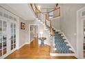 Elegant foyer features hardwood floors, staircase with carpet runner and white wooden banister at 206 Zapata Ln, Chapel Hill, NC 27517