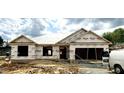 New construction of a single-story home, featuring a covered structure and visible framing under cloudy skies at 21 Shoreline Dr, Lillington, NC 27546