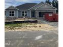 Charming single-story home with stone accents, gray siding, attached garage, and construction progress at 21 Shoreline Dr, Lillington, NC 27546