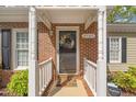 Close up of the front door with a wreath and white columns with the house number '2102' at 2102 Trailridge Ct, Raleigh, NC 27603