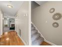 Hallway with hardwood floors, a staircase, leading into a living room with a fireplace at 2102 Trailridge Ct, Raleigh, NC 27603