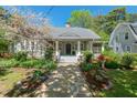Charming home with a stone pathway, a welcoming front porch, and mature landscaping with flowering plants at 2416 W Club Blvd, Durham, NC 27705