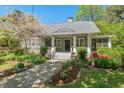Charming home with a stone pathway, a welcoming front porch, and mature landscaping with flowering plants at 2416 W Club Blvd, Durham, NC 27705